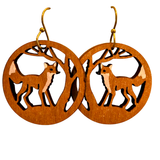 A pair of wooden dangle earrings with laser-cut fox and tree designs, featuring gold-tone fishhook ear wires, shown against a plain white background.