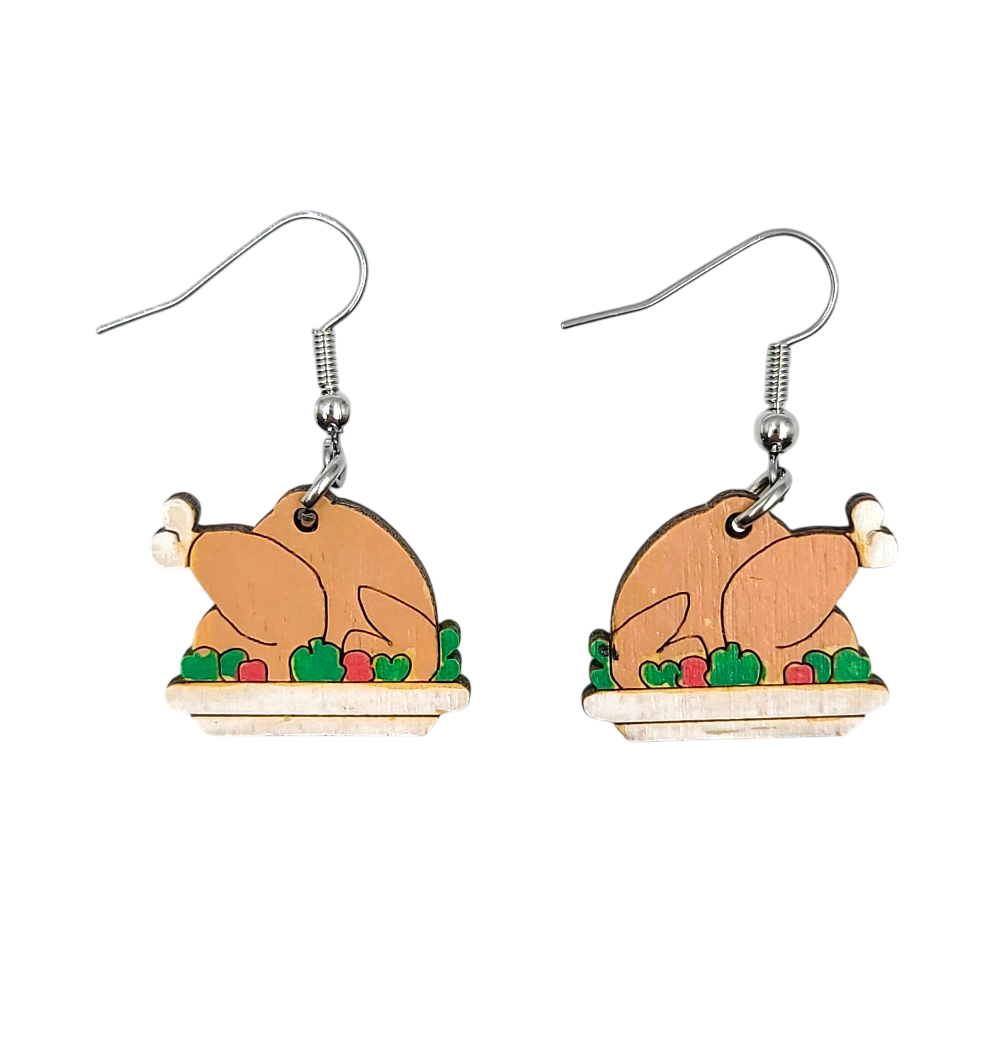 A pair of wooden turkey-shaped dangle earrings with silver fishhook wires, shown against a plain white background.