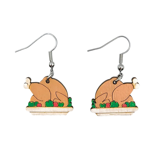 A pair of wooden turkey-shaped dangle earrings with silver fishhook wires, shown against a plain white background.